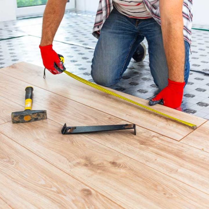 Handyman installing new laminated wooden floor